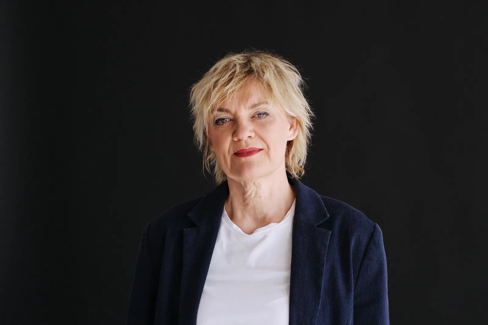 Anna Windmüller, sitzendes Studio-Portrait in dunkler Weste, ruhiger und konzentrierter Ausdruck