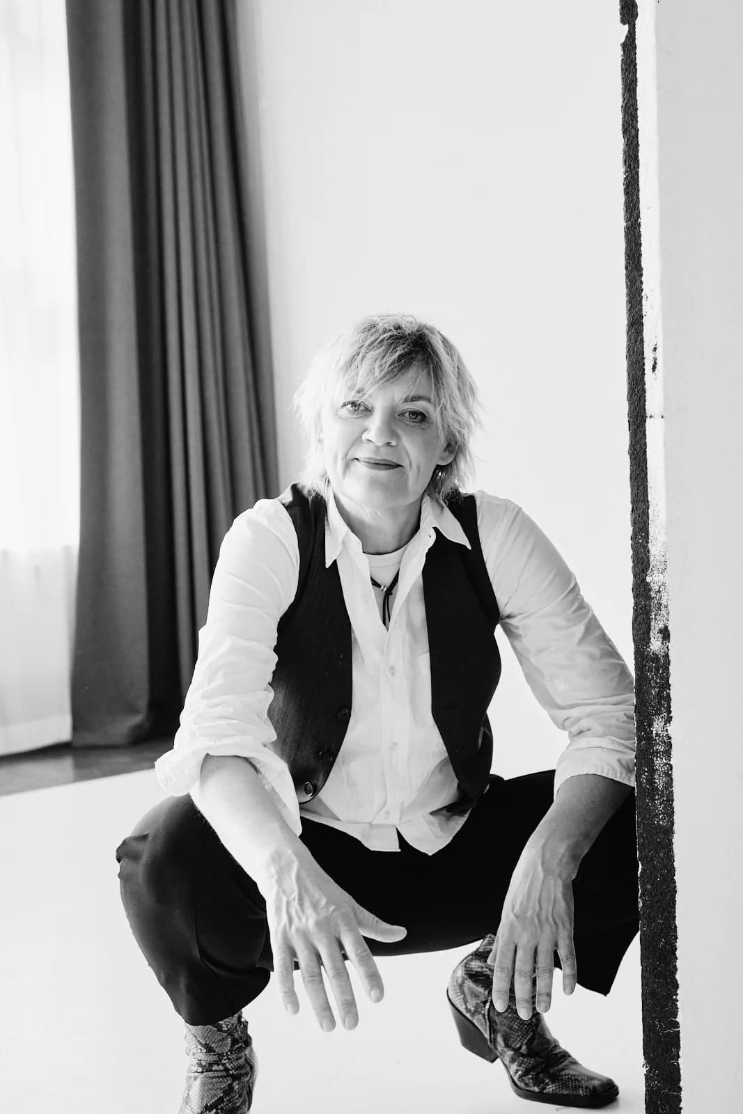 Anna Windmüller in der Hocke, geerdete Studio-Aufnahme — entspannte und präsente Körperhaltung