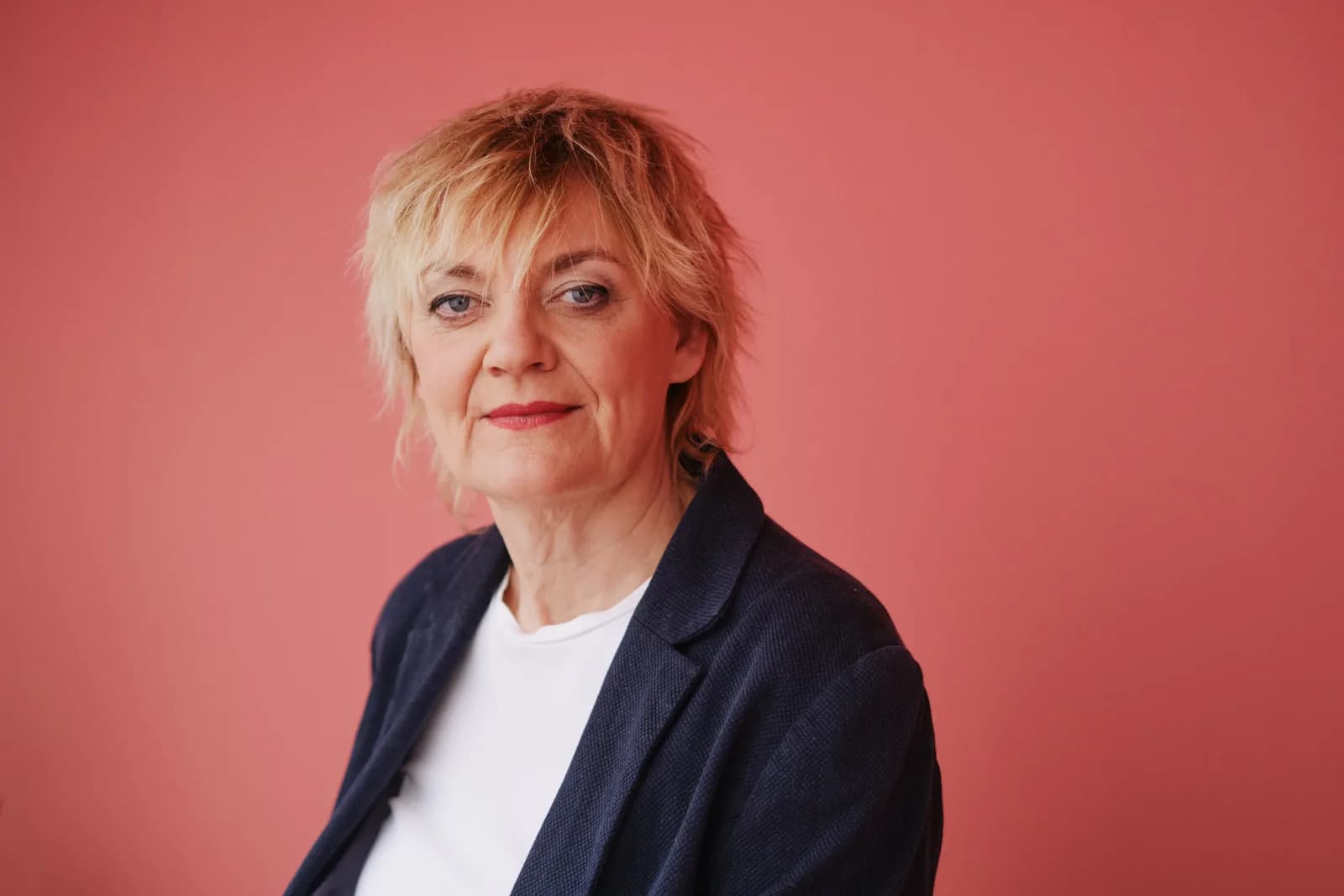 Anna Windmüller, Halbporträt im dunkelblauen Blazer vor schwarzem Hintergrund, ruhiger und souveräner Ausdruck