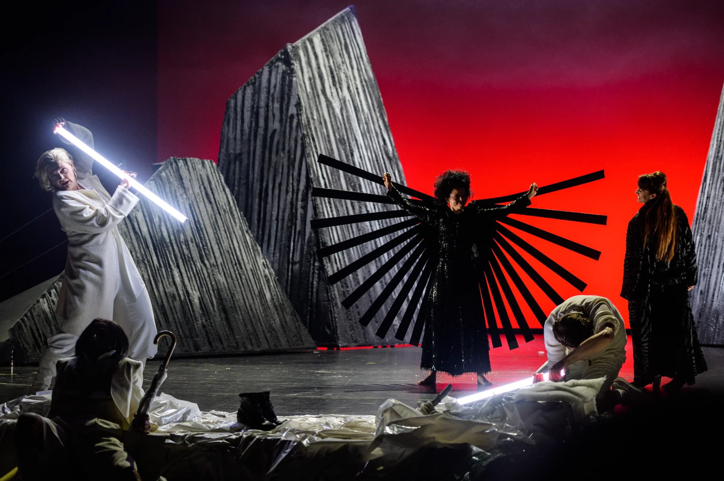 Anna Windmüller in einer dramatischen Theaterszene mit Lichtelement vor rotem Bühnenhintergrund — 30 Jahre Bühnenerfahrung im Höchstleistungsmodus